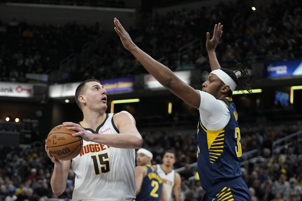 Denver Nuggets' Nikola Jokic (15) shoots over Indiana Pacers' Myles Turner (33) during the first half of an NBA basketball game, Tuesday, Jan. 23, 2024, in Indianapolis. (AP Photo/Darron Cummings)