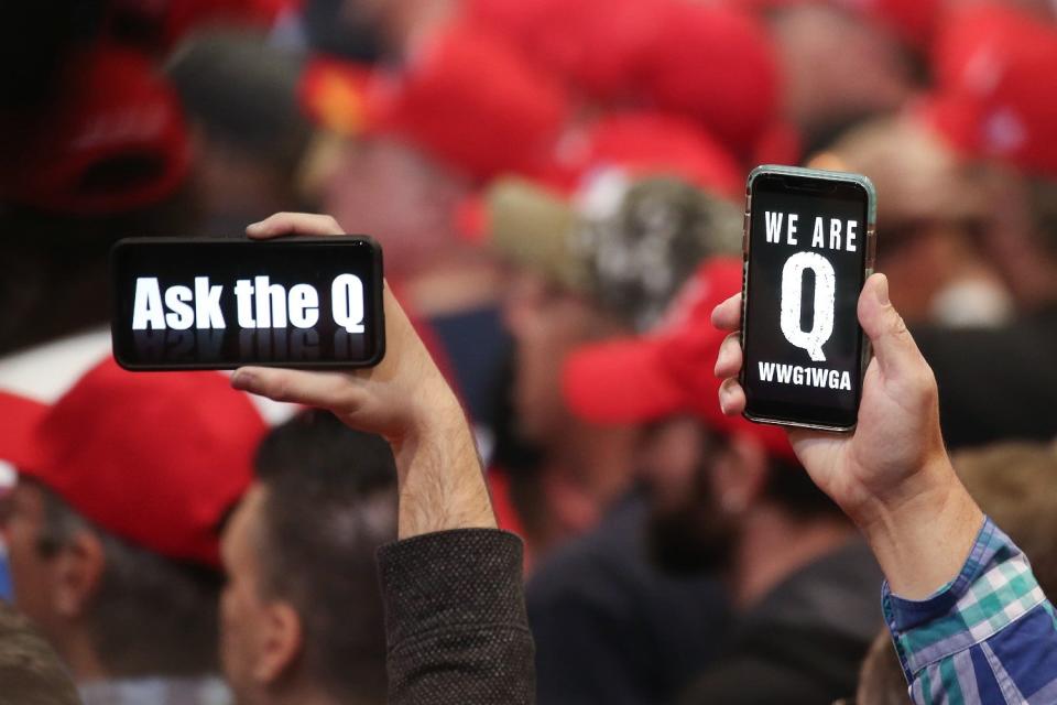 Supporters of President Donald Trump hold up their phones with messages referring to the QAnon conspiracy theory at a campaign rally at Las Vegas Convention Center on February 21, 2020 (Mario Tama/Getty Images)