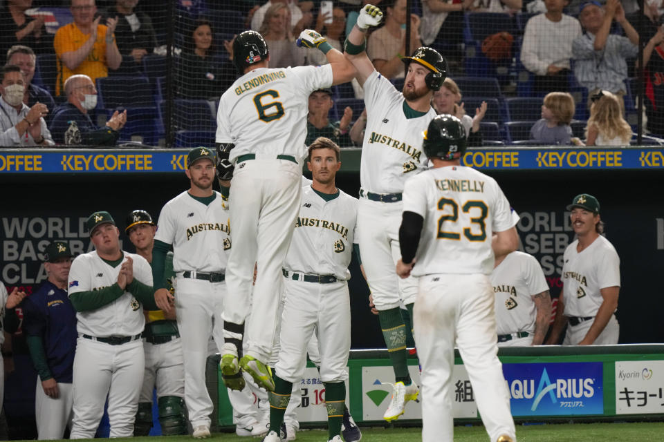 Robert Glendinning of Australia is congratulated by teammate Aaron Whitefield, second right, after making a home run during their Pool B game against China at the World Baseball Classic at the Tokyo Dome, Japan, Saturday, March 11, 2023. (AP Photo/Eugene Hoshiko)