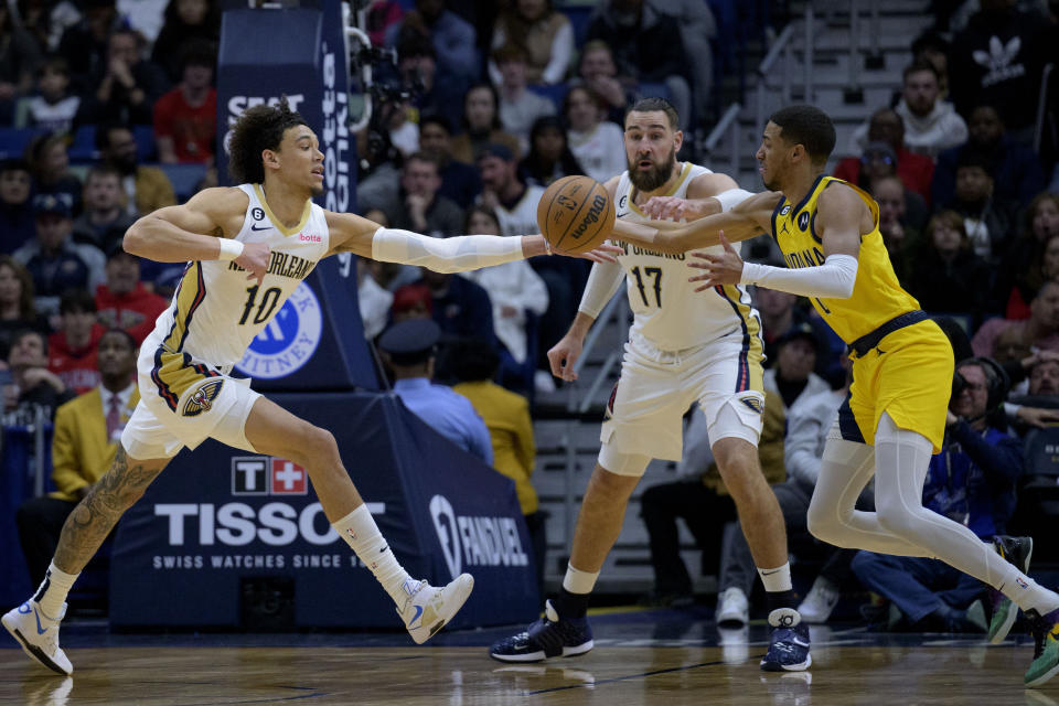 New Orleans Pelicans center Jaxson Hayes (10) and Indiana Pacers guard Tyrese Haliburton, right, battle for the ball next to Pelicans center Jonas Valanciunas (17) in the first half of an NBA basketball game in New Orleans, Monday, Dec. 26, 2022. (AP Photo/Matthew Hinton)