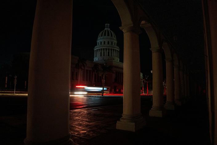 A bus passes in front of the capitol during a blackout in Havana, Cuba, Wednesday, Sept. 28, 2022. Cuba remained in the dark early Wednesday after Hurricane Ian knocked out its power grid and devastated some of the country's most important tobacco farms when it hit the island's western tip as a major storm.