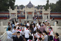 Students wearing face masks to protect against the coronavirus gather at the Temple of Heaven in Beijing, Saturday, July 18, 2020. Authorities in a city in far western China have reduced subways, buses and taxis and closed off some residential communities amid a new coronavirus outbreak, according to Chinese media reports. They also placed restrictions on people leaving the city, including a suspension of subway service to the airport. (AP Photo/Mark Schiefelbein)