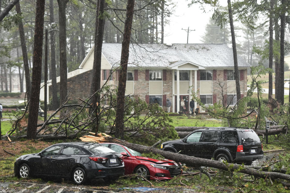 A fallen tree sits on a vehicle at an apartment complex damaged by severe weather Thursday, Feb. 6, 2020, in Spartanburg, S.C. A powerful winter storm raked the Deep South on Thursday with high winds, rain and floods across a dozen states. (AP Photo/Sean Rayford)