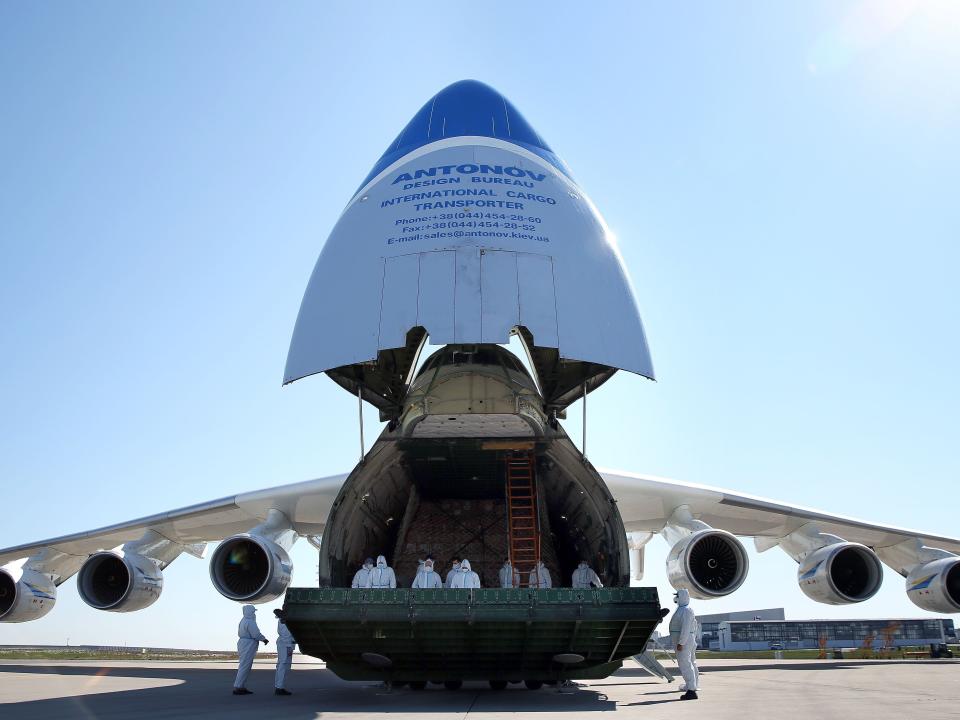 Crew members in protective suits stand inside an Antonov An-225 Mriya cargo aeroplane during a delivery of protective masks from China on April 27, 2020 at the airport of Leipzig, eastern Germany.