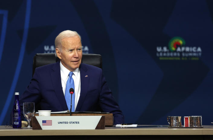 President Biden, seated, speaks at a meeting.