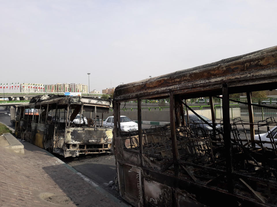 This photo released by the Iranian Students' News Agency, ISNA, shows scorched public buses that remained on the street after protests that followed authorities' decision to raise gasoline prices, in Tehran, Iran, Sunday, Nov. 17, 2019. Ayatollah Ali Khamenei, Iran's supreme leader, on Sunday backed the government's decision to raise gasoline prices and called angry protesters who have been setting fire to public property over the hike "thugs," signaling a potential crackdown on the demonstrations. (Morteza Zangane/ISNA via AP)