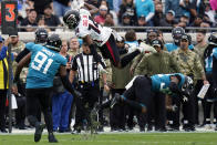 Atlanta Falcons wide receiver Russell Gage (14) leaps over Jacksonville Jaguars cornerback Tyson Campbell, right, as defensive end Dawuane Smoot (91) comes in to make the stop during the first half of an NFL football game, Sunday, Nov. 28, 2021, in Jacksonville, Fla. (AP Photo/Chris O'Meara)