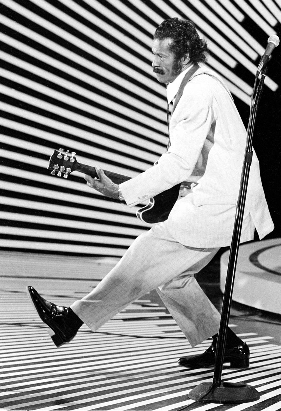 ARCHIVO - En esta fotografía del 4 de abril de 1980, el guitarrista y cantante Chuck Berry hace el "paso del pato" mientras toca la guitarra en el escenario. La policía en Missouri dijo que Berry murió a los 90 años el sábado 18 de marzo de 2017. (AP Foto)