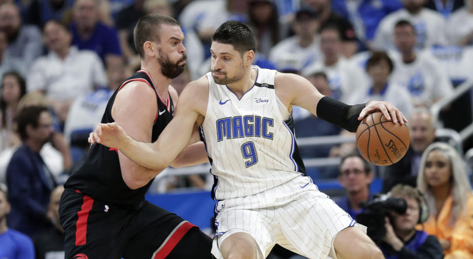 Orlando Magic's Nikola Vucevic (9) tries to get past Toronto Raptors' Marc Gasol. (AP Photo/John Raoux)