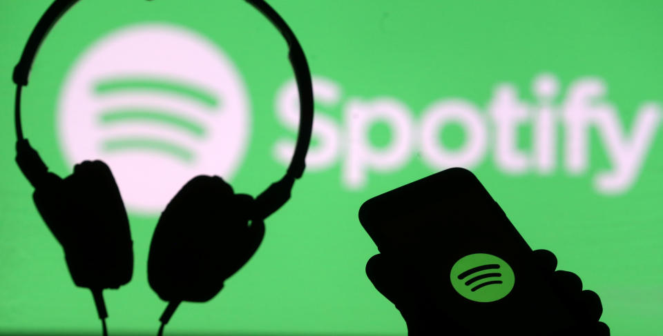 A smartphone and a headset are seen in front of a screen projection of Spotify logo, in this picture illustration taken April 1, 2018. REUTERS/Dado Ruvic/Illustration