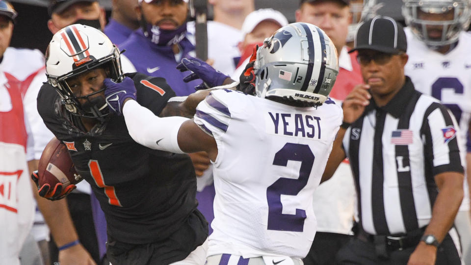 Kansas State defensive back Russ Yeast (2) grabs the face mask of Oklahoma State wide receiver Tay Martin (1) during the first half of an NCAA college football game Saturday, Sept. 25, 2021, in Stillwater, Okla. (AP Photo/Brody Schmidt)