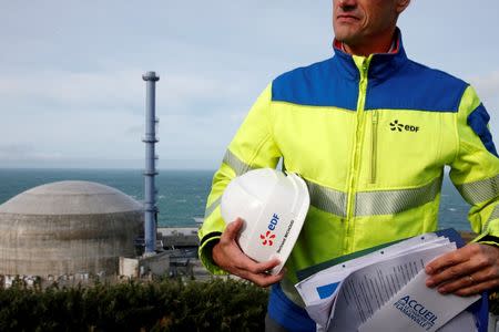 FILE PHOTO: An EDF employee stands in front of the construction site of the third-generation European Pressurised Water nuclear reactor (EPR) in Flamanville, France. November 16, 2016. REUTERS/Benoit Tessier/File Photo
