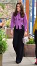 <p>The Duchess chose a wide-legged trouser paired with a purple pussybow blouse for her visit to the Henry Fawcett Children's Centre. She paired the look with a small top-handled bag and black pumps.</p>