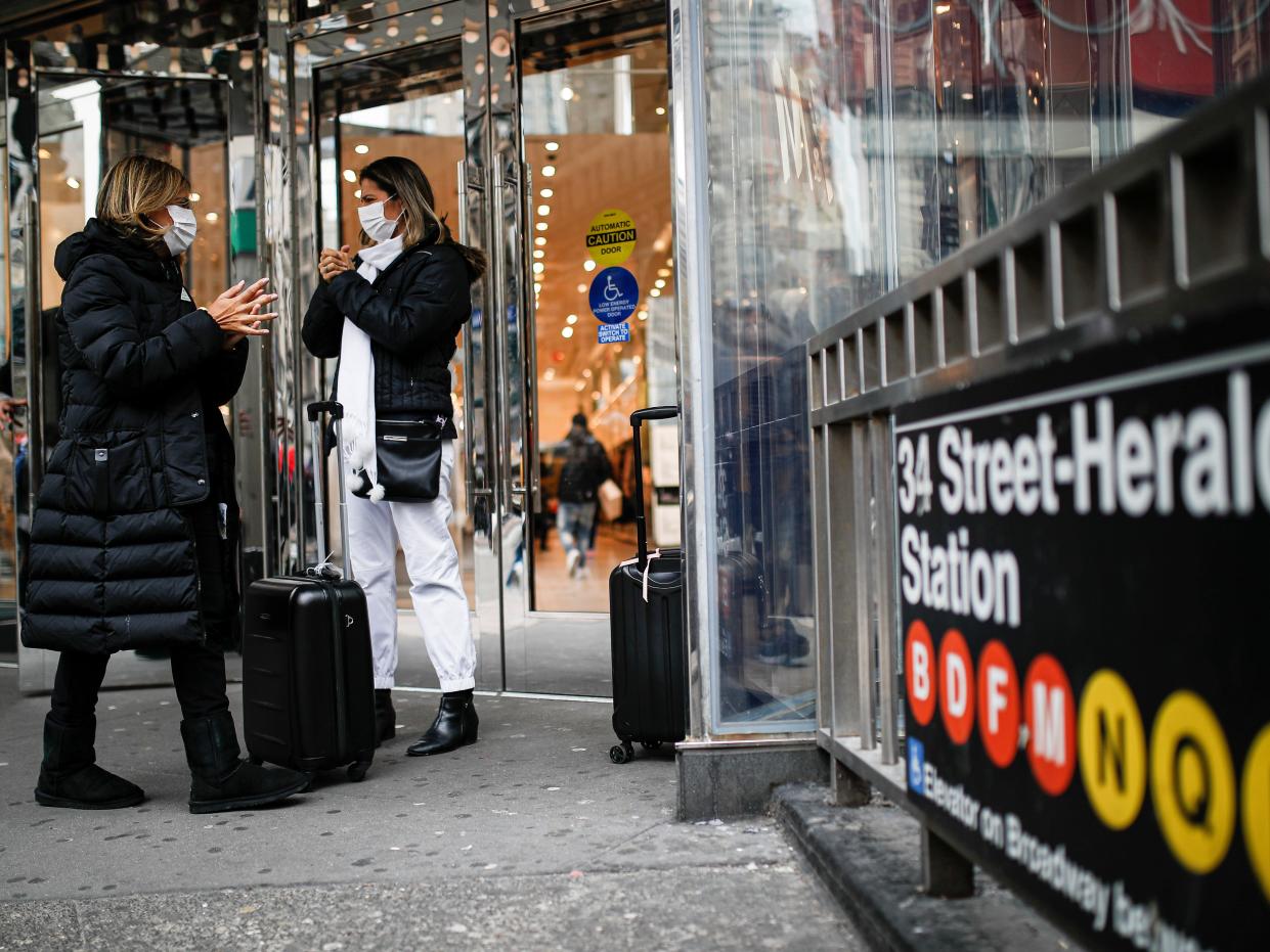 Shoppers wear face masks and sanitize their hands on the sidewalk at Herald Square.