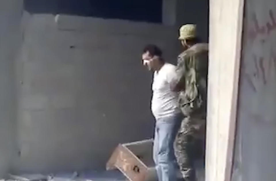 This frame grab from a 2013 video, shows Syrian Wassim Siyam blindfolded being forced into a large pit full of bodies and shot dead by a Syrian soldier, in the Tadamon neighborhood of Damascus, Syria. For many years, the Siyam family believed their adult son was being held at a government prison after he went missing at a checkpoint nearly a decade ago. Last month, the hope that he would one day return came to an abrupt end after a newly released video taken in 2013 showed him among dozens of blindfolded young men who were thrown into a large pit and shot dead by Syrian agents, who then set the bodies on fire. (AP Photo)