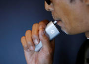 A staff of British American Tobacco Japan demonstrates its new tobacco heating system device 'glo' after a news conference in Tokyo, Japan, November 8, 2016. REUTERS/Kim Kyung-Hoon