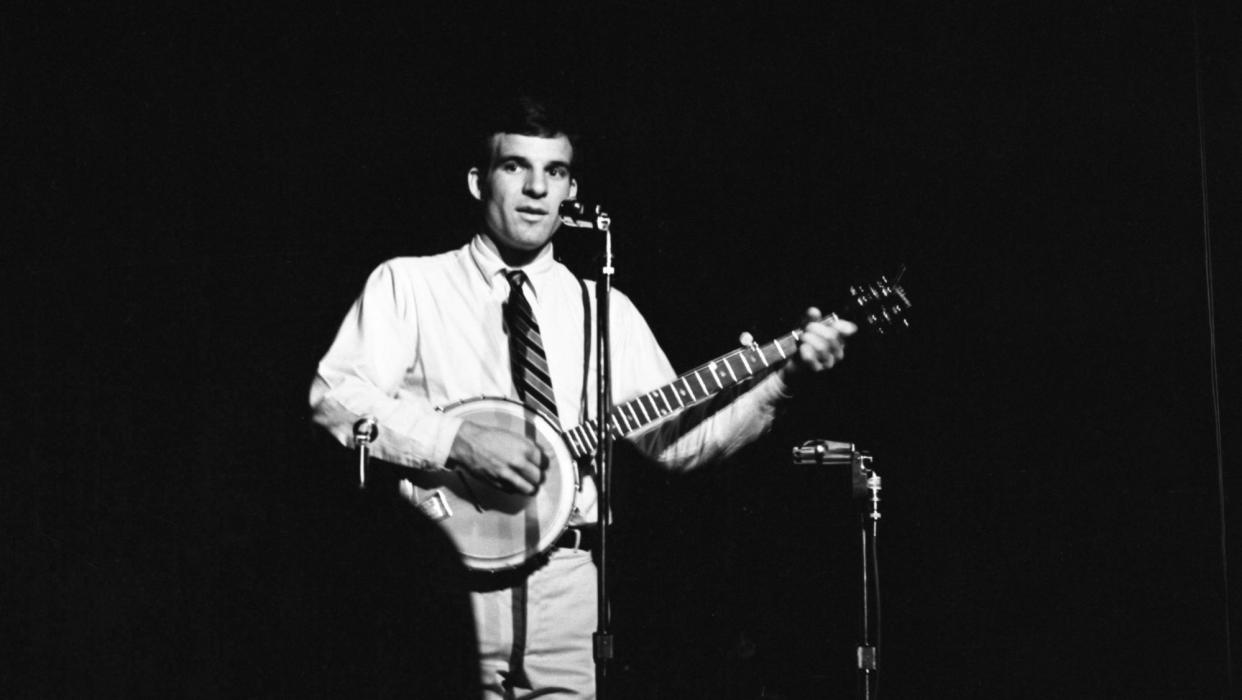  Steve Martin with a banjo on stage. 