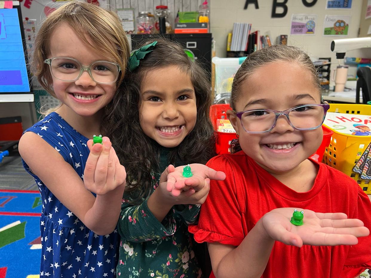 Students at Novi Woods Elementary School show off the plastic frogs they found for Leap Day on Feb. 29, 2024.