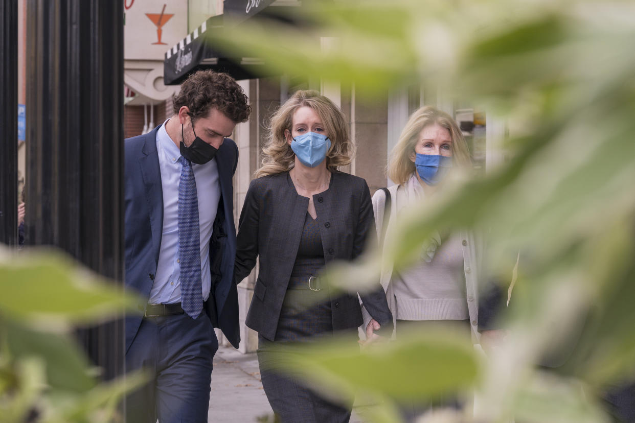 Elizabeth Holmes, center, leaves federal court in San Jose, Calif., Monday, Jan. 3, 2022. The jury weighing fraud charges against the former Theranos CEO on Monday informed the judge they are deadlocked on three of the 11 counts she faces.(AP Photo/Nic Coury)