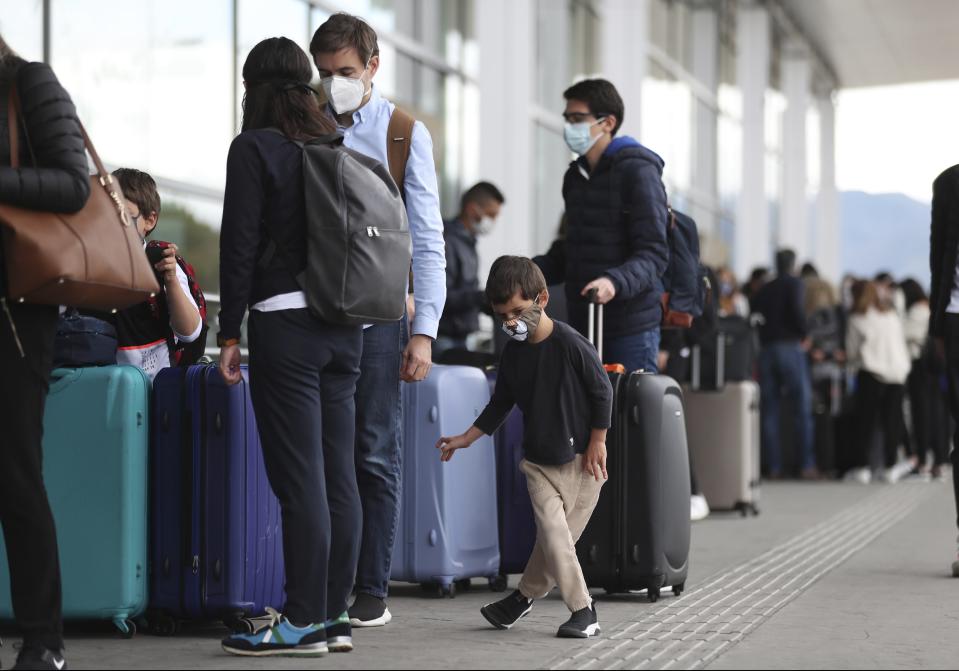 Passengers stand in line for a domestic, commercial flight at El Dorado airport in Bogota, Colombia, Tuesday, Sept. 1, 2020. Airports, land transport, restaurants, and gyms are reopening in most of Colombia this week, as the South American nation attempts to reignite its economy following months of restrictions related to the coronavirus pandemic. (AP Photo/Fernando Vergara)