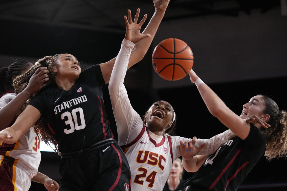 Stanford guard Haley Jones (30) and forward Brooke Demetre (21) grapple for a loose ball with Southern California guard Okako Adika (24) during the first half of an NCAA college basketball game Sunday, Jan. 15, 2023, in Los Angeles. (AP Photo/Mark J. Terrill)