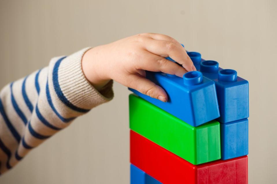 A preschool age child plays with plastic building blocks (Dominic Lipinski/PA) (PA Archive)