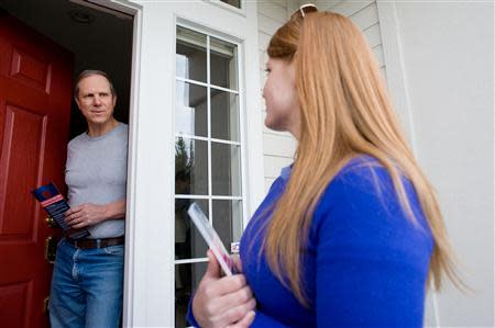 Stacey Barrack, hired by the Defending Main Street super PAC to get out the vote for Congressman Mike Simpson (R-ID), speaks with resident John Evans about the upcoming Republican primary election in Boise, Idaho May 10, 2014. REUTERS/Patrick Sweeney