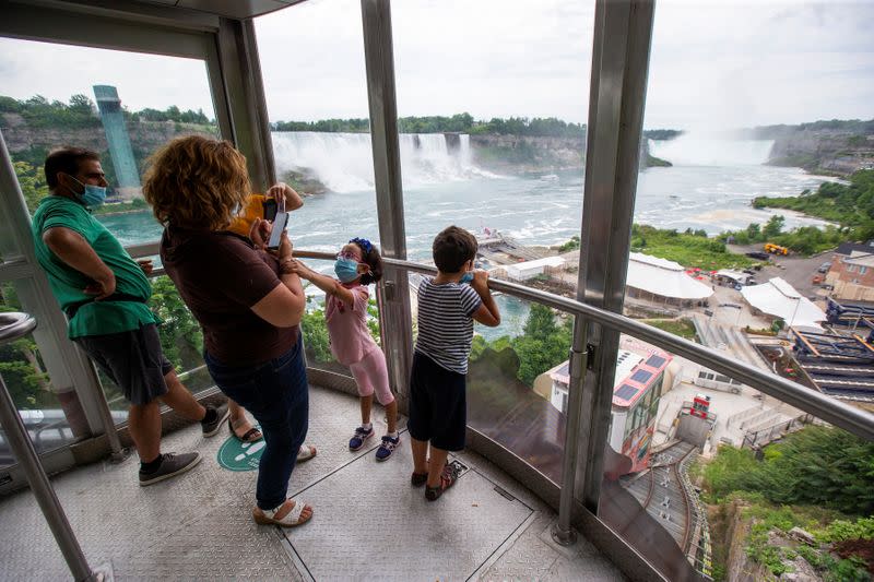 Canadian tourists take photos as they travel down to the Hornblower tourist boat, limited under Ontario's rules to just six passengers amid the spread of the coronavirus disease (COVID-19), in Niagara Falls