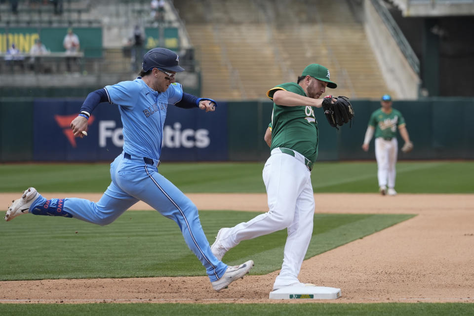 Oakland Athletics pitcher Jack O'Loughlin, right, steps on first base for the out on Toronto Blue Jays' Danny Jansen, left, during the seventh inning of a baseball game Saturday, June 8, 2024, in Oakland, Calif. (AP Photo/Godofredo A. Vásquez)