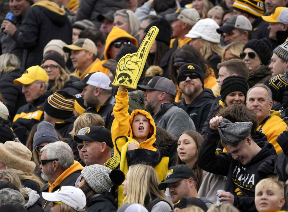 A young Iowa fan, center, cheers on the team against Rutgers during the first half of an NCAA college football game, Saturday, Nov. 11, 2023, in Iowa City, Iowa. (AP Photo/Bryon Houlgrave)