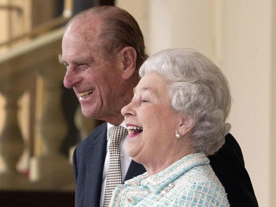 Queen Elizabeth and Prince Philip laugh in 2004.