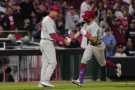 Philadelphia Phillies' Kody Clemens, right, celebrates with third base coach Dusty Wathan, left, as he rounds the bases after hitting a three-run home run in the ninth inning of a baseball game against the Cincinnati Reds,Monday, April 22, 2024, in Cincinnati. The Phillies won 7-0. (AP Photo/Carolyn Kaster)
