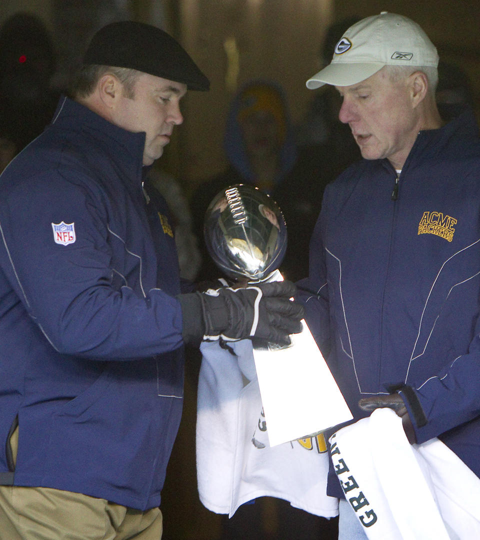 FILE - In this Feb. 8, 2011, file photo, Green Bay Packers general manager Ted Thompson, right, hands the Vince Lombardi Trophy to coach Mike McCarthy before walking onto the field for the "Return to Titletown" celebration at Lambeau Field in Green Bay, Wis. Thompson, whose 13-year run as Green Bay Packers general manager included their 2010 Super Bowl championship season, died Wednesday, Jan 20, the team announced Thursday, Jan. 21, 2021. He was 68. Thompson was Packers general manager from 2005-17 and drafted many notable players on the current roster, including two-time MVP quarterback Aaron Rodgers. (AP Photo/Mike Roemer, File)