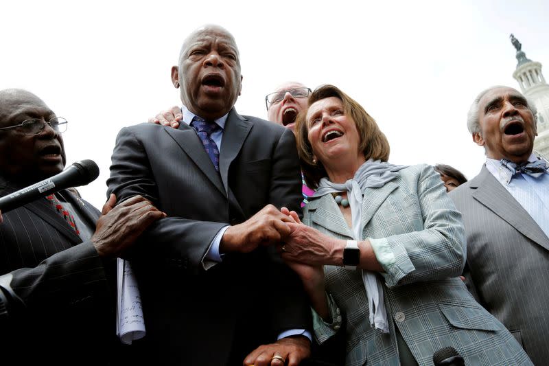 FILE PHOTO: U.S. House Minority Leader Nancy Pelosi (D-CA) holds hands with Rep. John Lewis (D-GA) as they sing along with House Democrats after their sit-in over gun-control law on Capitol Hill in Washington