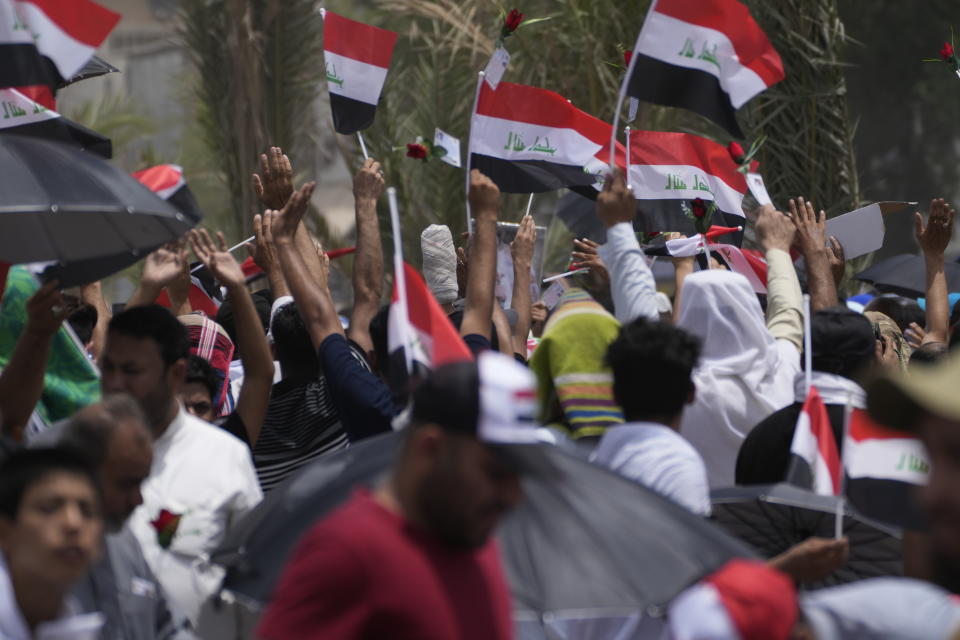 Followers of Shiite cleric Muqtada al-Sadr wave Iraqi flags while They listening to their leader during an open-air Friday prayers in Sadr City, Baghdad, Iraq, Friday, July 15, 2022. (AP Photo/Hadi Mizban)