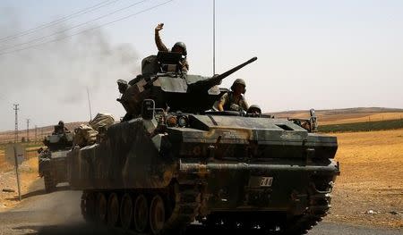 A Turkish soldier on an armoured personnel carrier waves as they drive from the border back to their base in Karkamis on the Turkish-Syrian border in the southeastern Gaziantep province, Turkey, August 27, 2016. REUTERS/Umit Bektas