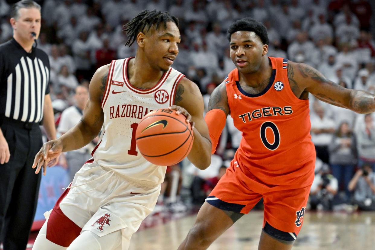 Arkansas guard JD Notae (1) drives past Auburn guard K.D. Johnson (0) during an NCAA college basketball game Tuesday, Feb. 8, 2022, in Fayetteville, Ark. (AP Photo/Michael Woods)