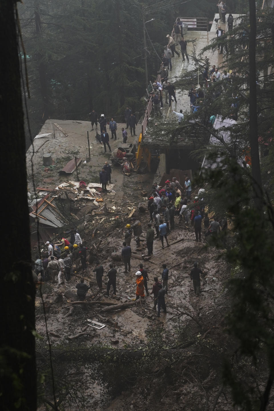 Rescuers remove mud and debris as they search for people feared trapped after a landslide near a temple on the outskirts of Shimla, Himachal Pradesh state, Monday, Aug.14, 2023. Heavy monsoon rains triggered floods and landslides in India's Himalayan region, leaving more than a dozen people dead and many others trapped, officials said Monday. (AP Photo/ Pradeep Kumar)