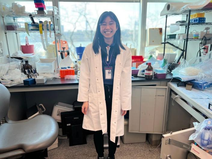 Image of 16-year-old Natasha Kulviwat in a white labcoat and lab setting.