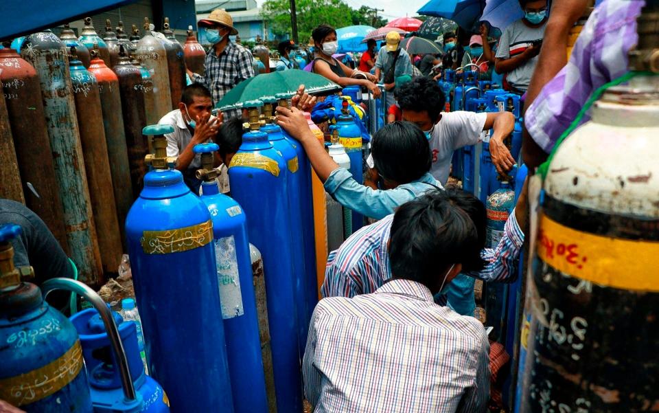 People wait in line for oxygen tanks to be refilled outside the Naing oxygen factory in Yangon, Myanmar on 28 July 2021 - AP/AP