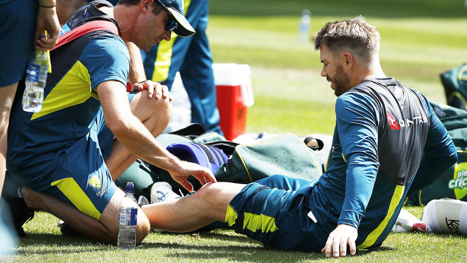 David Warner was assessed by team physio David Beakley before leaving the session. (Photo by Ryan Pierse/Getty Images)
