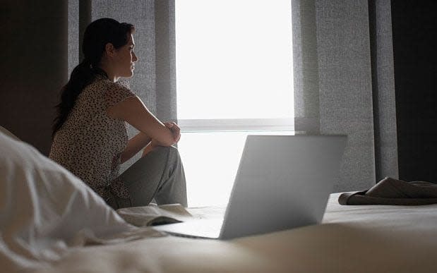 Woman sat alone on her bed