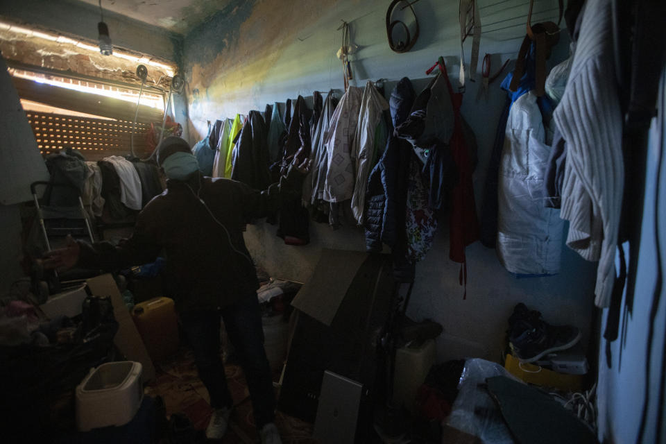 In this photo taken on Monday, April 27, 2020, Jimmy Donko, 43 from Ghana, shows his room, illuminated by a ray of sunshine filtering through a broken shutter, in the house where he lives with other 45 men, from Nigeria and Ghana, in Castel Volturno, near Naples, Southern Italy. The home has no running water, the dilapidated electrical system doesn't reach many rooms that are in the dark. They are known as “the invisibles,” the undocumented African migrants who, even before the coronavirus outbreak plunged Italy into crisis, barely scraped by as day laborers, prostitutes and seasonal farm hands. Locked down for two months in their overcrowded apartments, their hand-to-mouth existence has grown even more precarious with no work, no food and no hope. (AP Photo/Alessandra Tarantino)