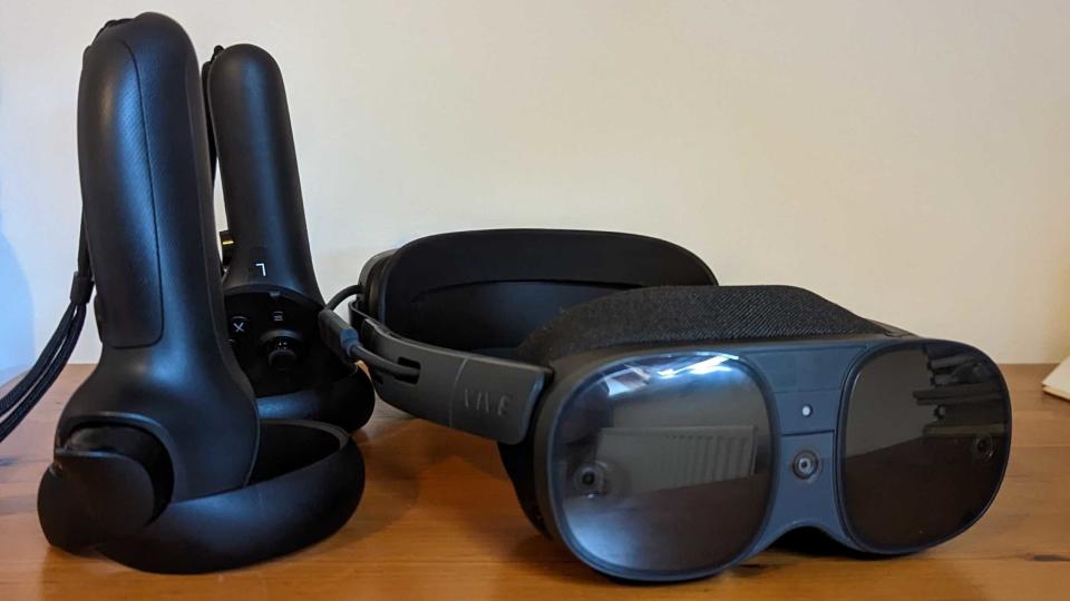 The Vive XR Elite and its controllers on a wooden table