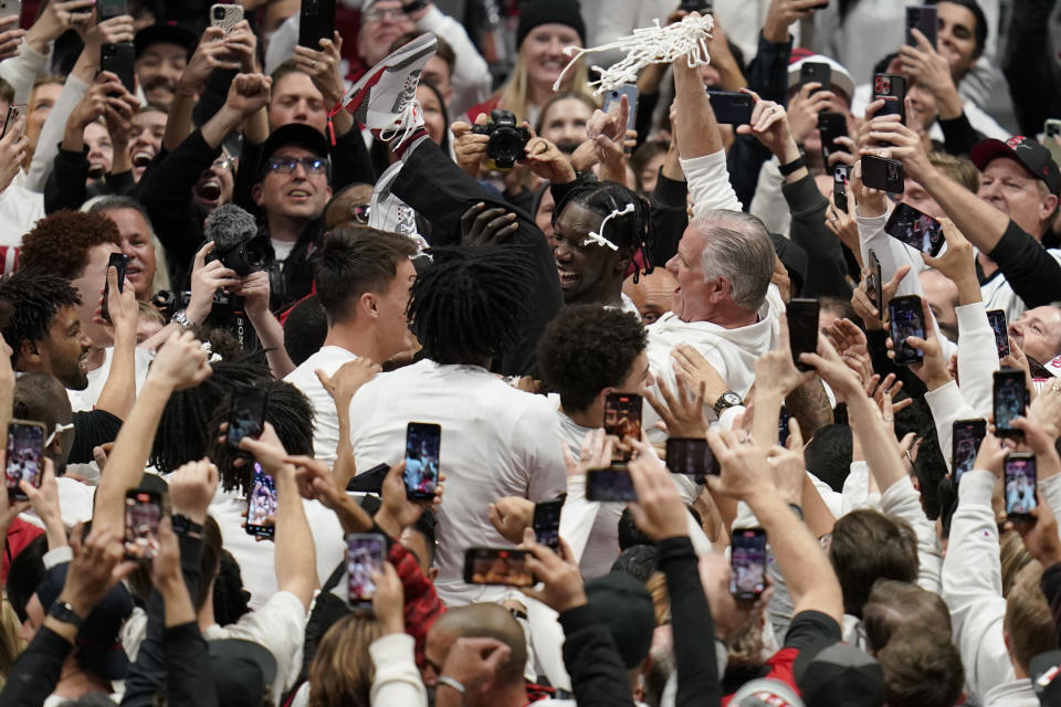 San Diego State head coach Brian Dutcher, right, is carried by team players after San Diego State defeated Wyoming in an NCAA college basketball game to win the Mountain West Conference Saturday, March 4, 2023, in San Diego. (AP Photo/Gregory Bull)