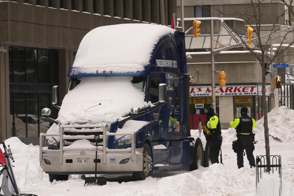 Police inspect one of the last remaining trucks in downtown Ottawa on Sunday, Feb. 20, 2022. A protest, which was first aimed at a COVID-19 vaccine mandate for cross-border truckers but also encompassed fury over the range of COVID-19 restrictions. (Adrian Wyld/The Canadian Press via AP)