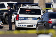 A Phoenix police officer stands outside the scene of a deadly shooting early Monday, March 30, 2020, in Phoenix. Phoenix police say one of their commanders was killed and two other officers were wounded as they responded to a domestic dispute. Authorities say Cmdr. Greg Carnicle and officers were called to a home in the northern part of Phoenix Sunday night over a roommate dispute when the suspect refused to cooperate and shot them. The suspect was not identified and was pronounced dead at the scene. (AP Photo/Matt York)