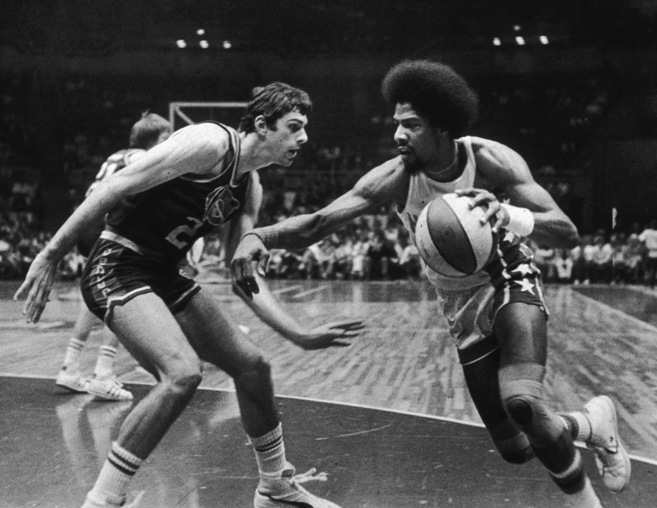 6th May 1976:  American basketball player Julius Erving of the New Jersey Nets, nicknamed 'Dr  J,' driving past Bobby Jones of the Denver Nuggets during a game.  (Photo by Larry C. Morris/New York Times Co./Getty Images)