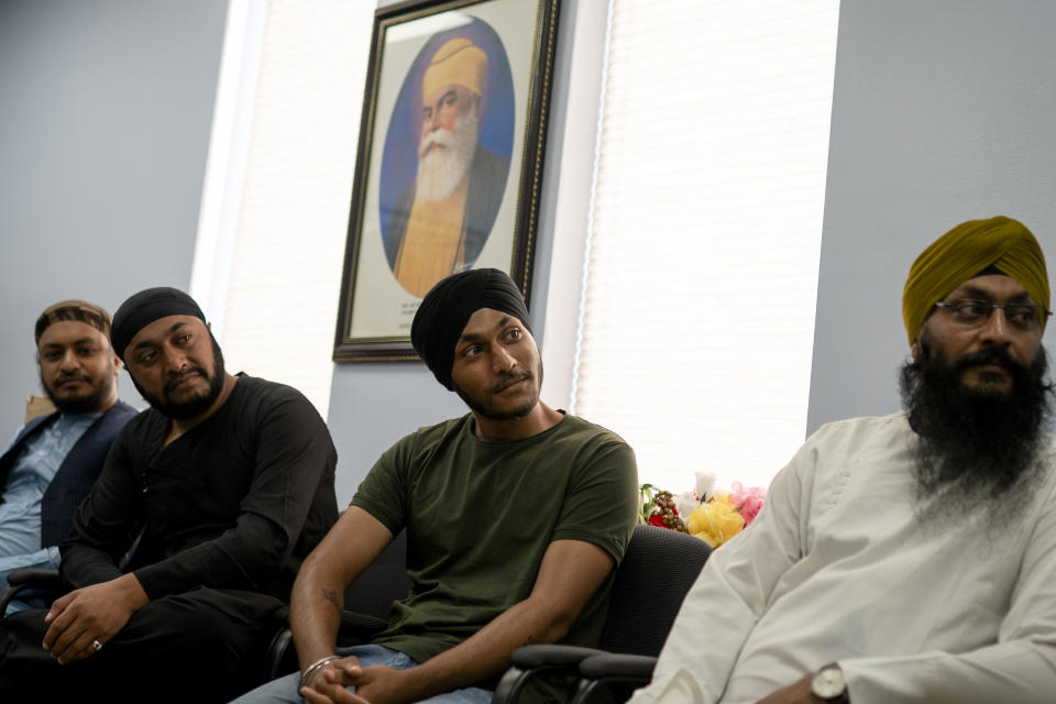 Kulwinder Singh Soni sits, center, sits with members of his family in the office space of Guru Nanak Darbar of Long Island, a Sikh gurudwara, Wednesday, Aug. 24, 2022, in Hicksville, N.Y. Their Afghan Sikh family of 13 has found refuge in the diaspora community on Long Island where the Sikh community is helping family members obtain work permits, housing, healthcare and find schools for the children. (AP Photo/John Minchillo)