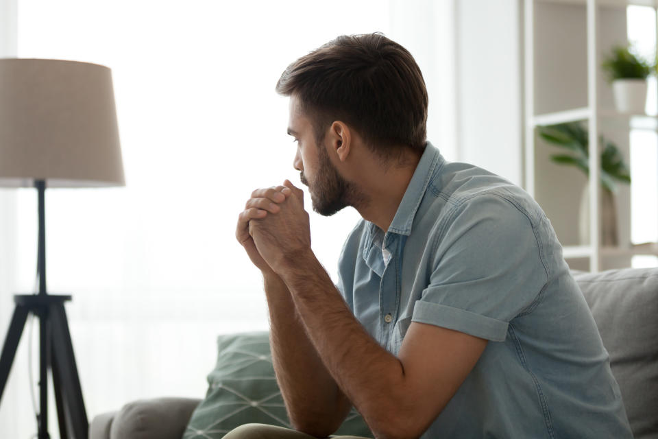 Man feeling anxious on sofa. (Getty Images)